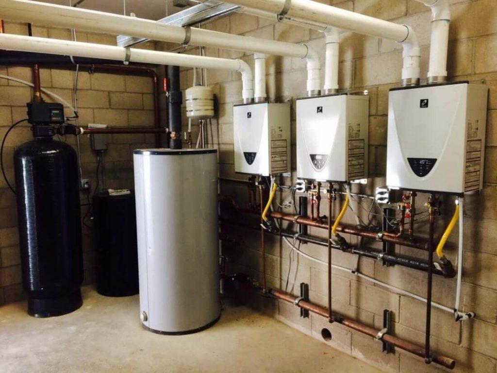 A mechanical room with wall-mounted boilers connected to organized piping and supported by nearby heating system components.